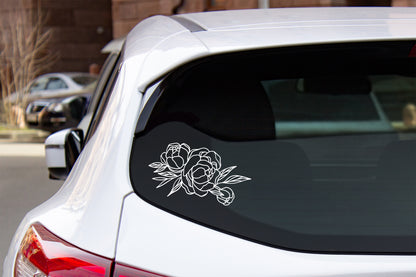 A vinyl decal of a bouquet of peony flowers applied to the rear window of a car.