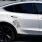 White car with a floral decal on the side, parked outdoors.