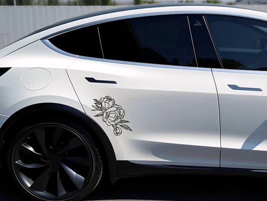 White car with a floral decal on the side, parked outdoors.